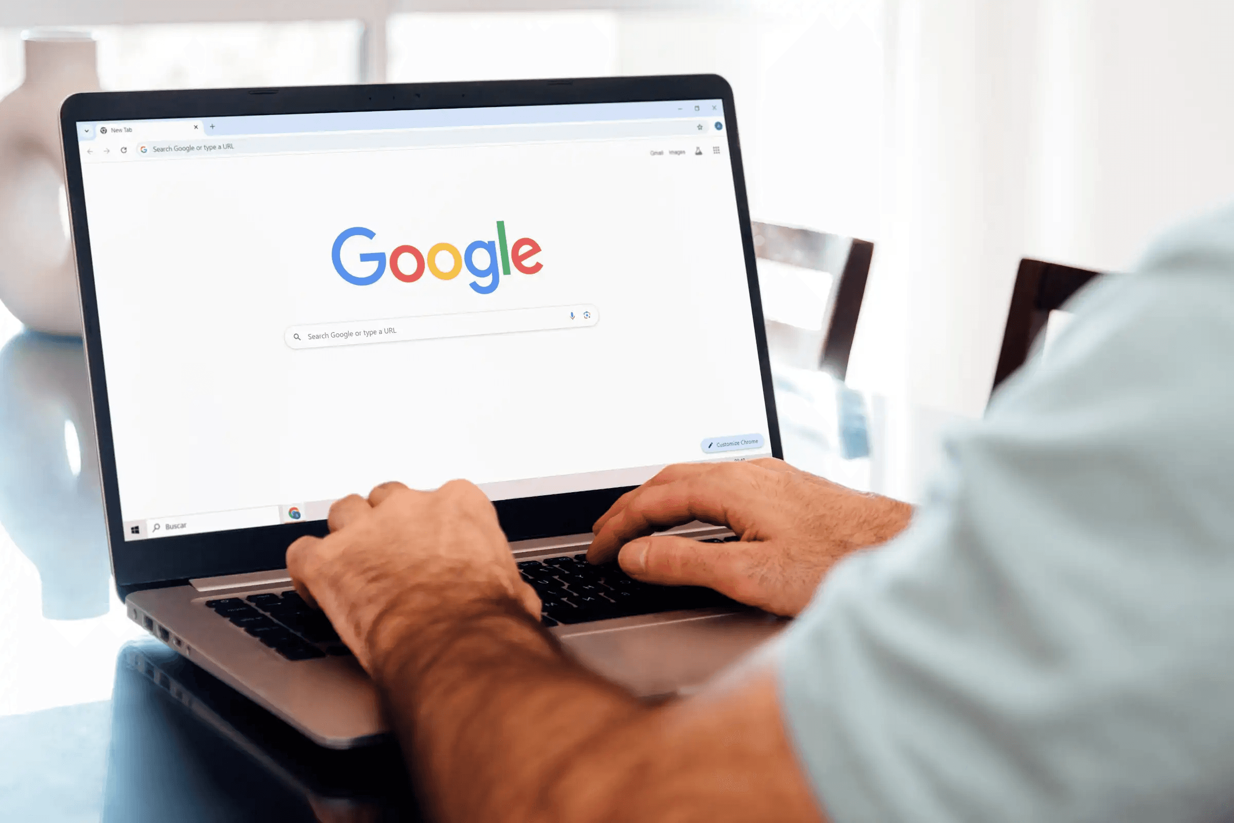 Person typing a search query into Google on a laptop, representing SEO and search visibility